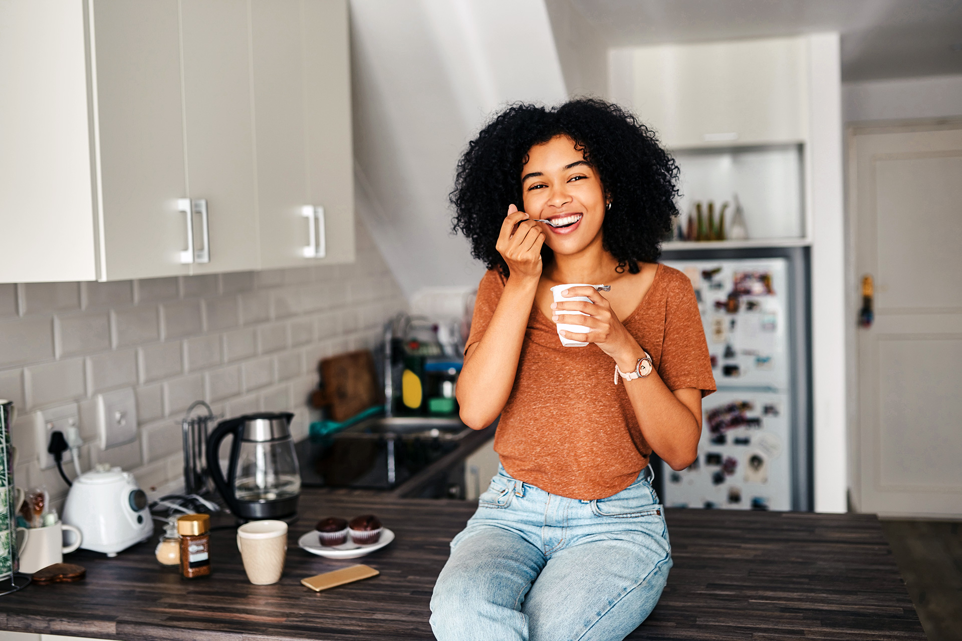 Young woman sitting on a counter eating